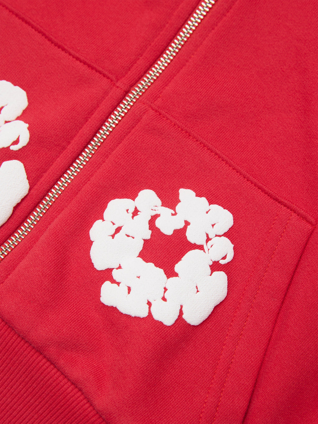 Red Denim Tears hoodie with white floral patterns on the chest and sleeve
