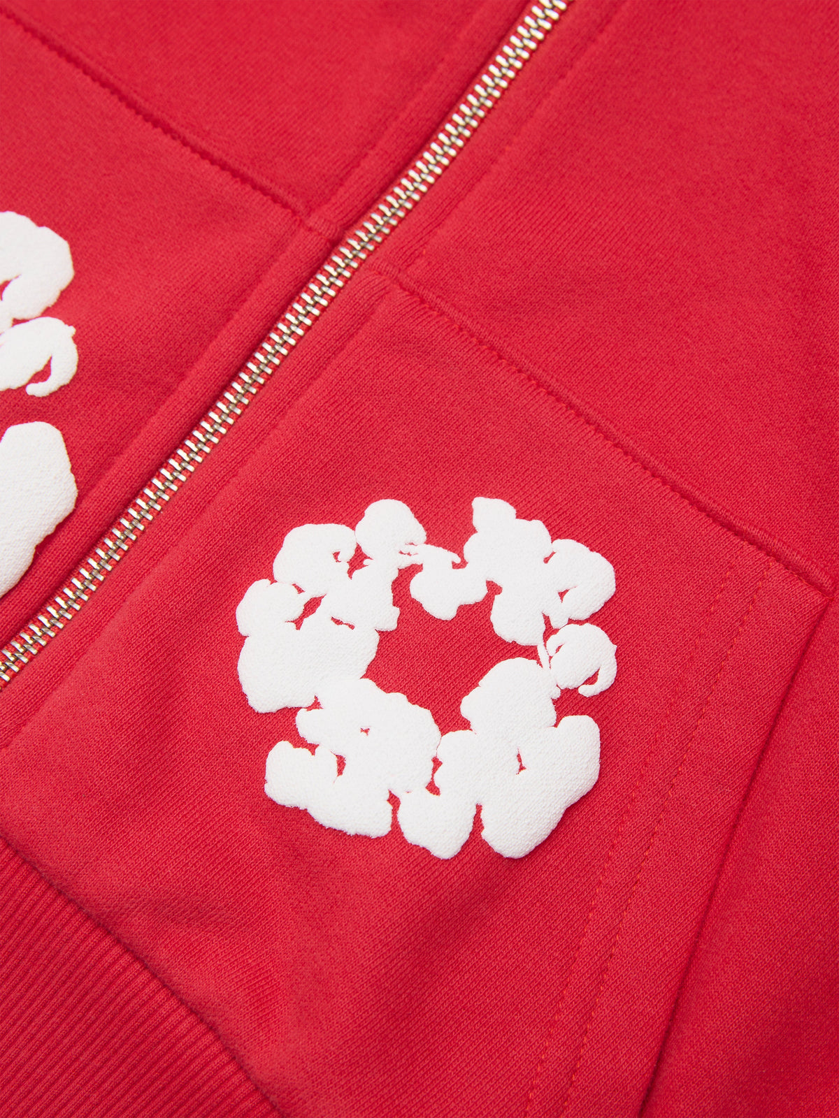 Red Denim Tears hoodie with white floral patterns on the chest and sleeve