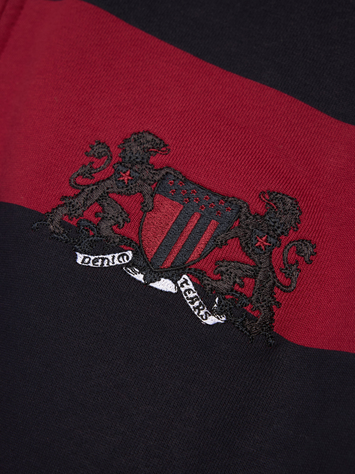 Denim Tears Embroidered logo on a red and black garment